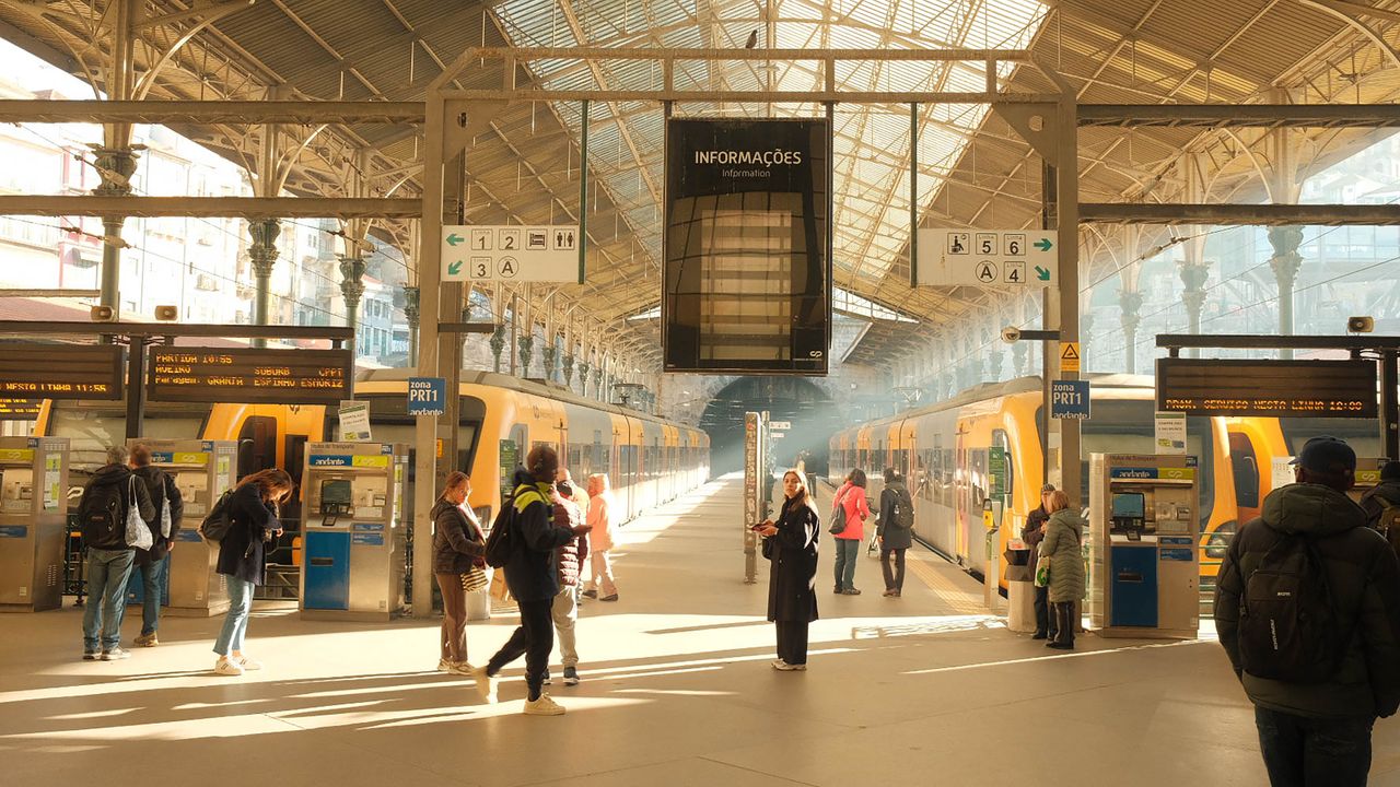 Commuters in the bright interior of São Bento Train Station, Porto, Portugal.